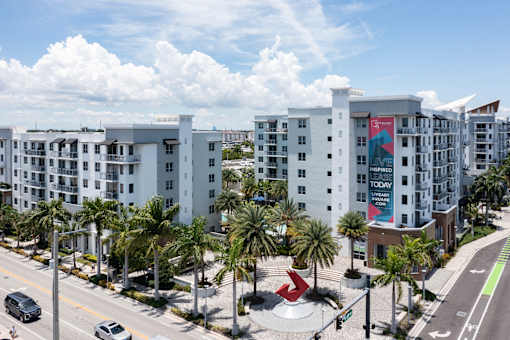 A modern apartment complex with a red sculpture in front.