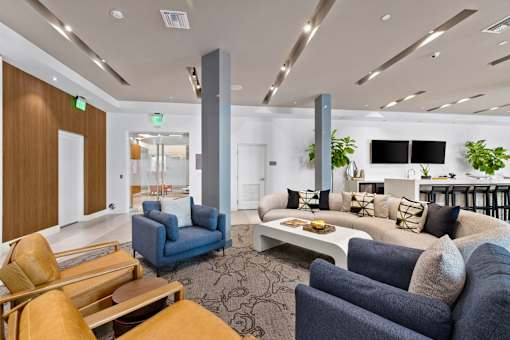 A modern living room with a white couch and a blue chair.
