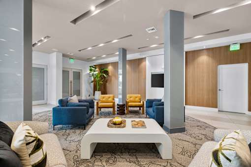 A modern living room with a white coffee table and blue chairs.