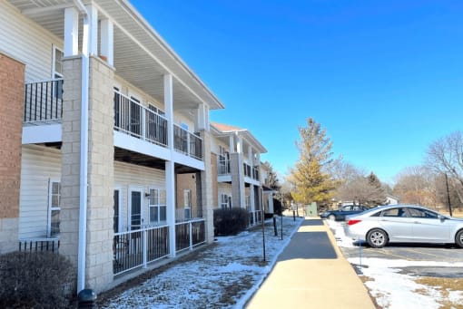 several private apartment balconies in front of the parking lot with snow on the ground at Algonquin Manor