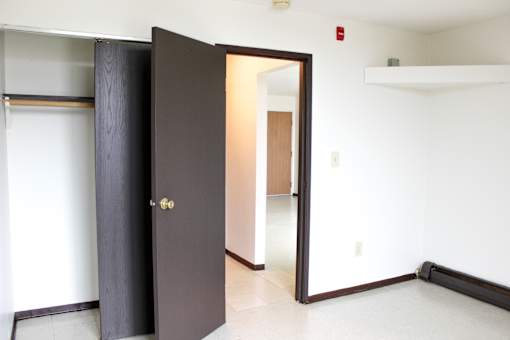 A black door with a gold handle is open.