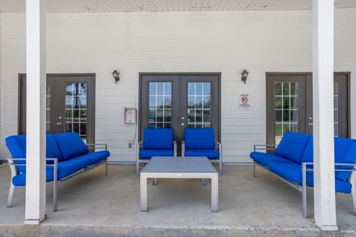 a patio with blue chairs and a coffee table