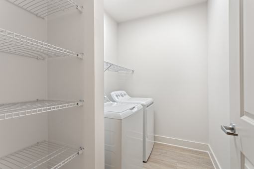a laundry room with a washer and dryer and a closet with shelves