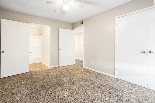 A room with white doors and a carpeted floor.