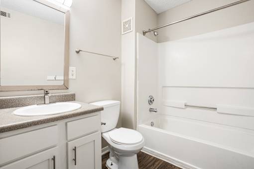 A white toilet sits next to a sink in a bathroom.