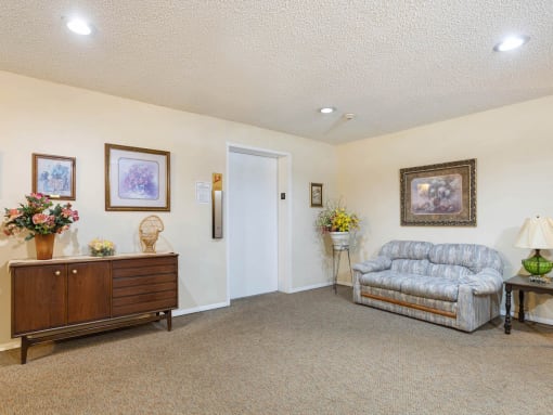 a lobby with a couch, credenza, and elevator at Village Square