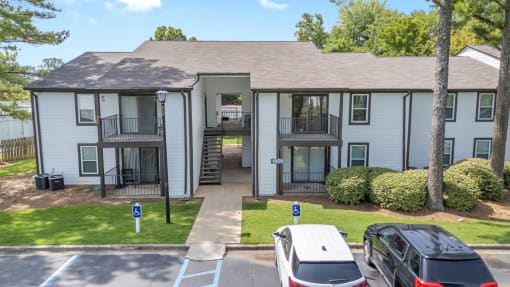 a white apartment building with cars parked in front of it