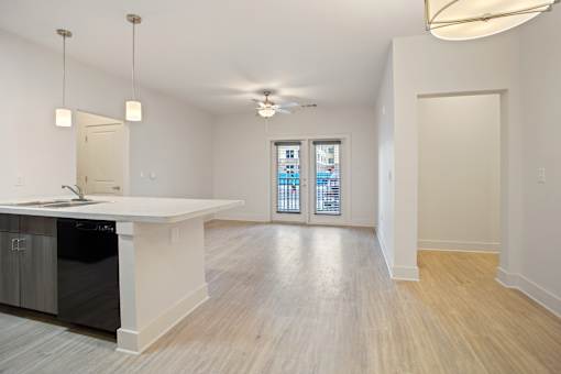 a kitchen and living room with a white counter top and a ceiling fan