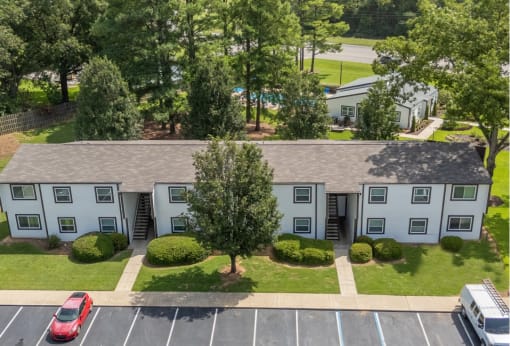 an aerial view of an apartment building in a parking lot