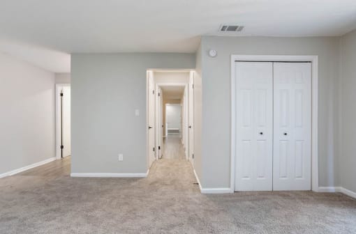 a bedroom with a double closets and a carpeted floor