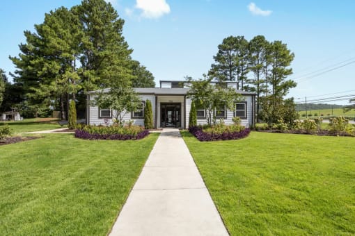 a house with a lawn and a sidewalk in front of it