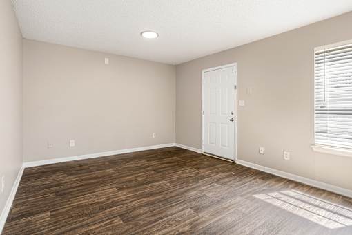 A room with a white door and a window with blinds.