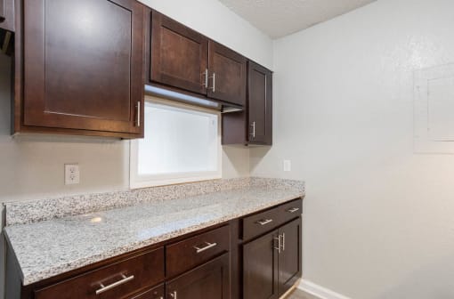 quartz countertops and dark cabinetry in an apartment kitchen at The Onyx Hoover