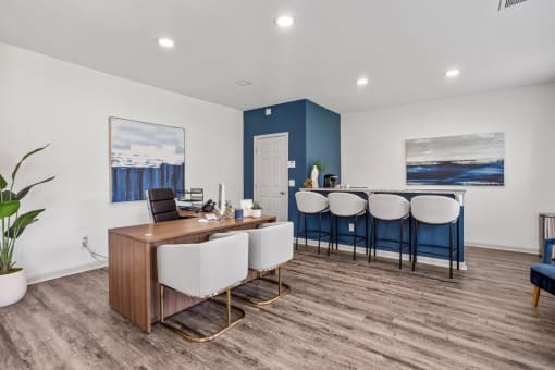 an office with a desk and chairs and a bar with a blue and white wall