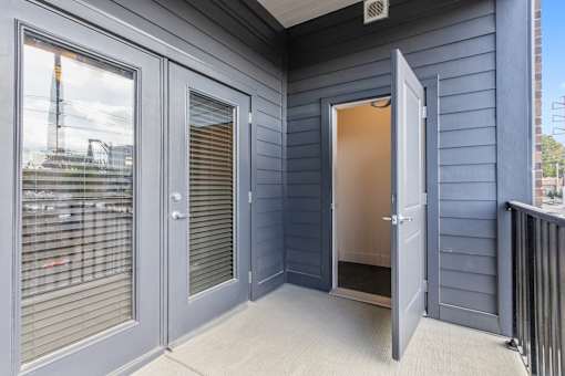the front porch of a with doors and a door open to a doorway