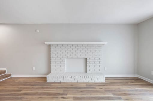 an updated Onyx Hoover apartment living room with a brick fireplace painted white