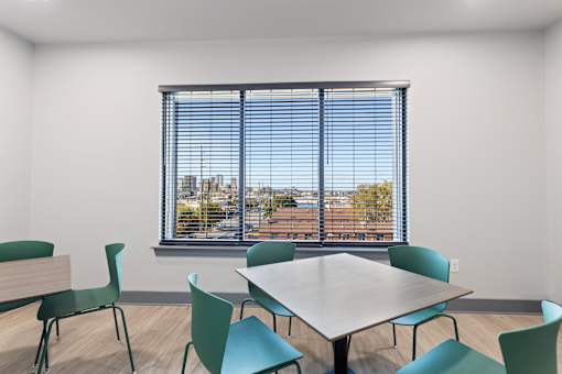 a classroom with a large window and a table and chairs