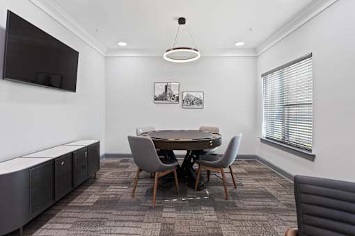 a conference room with a table and chairs and a television