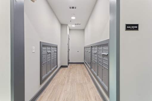 a view of the mailboxes in a long hallway with wood floors