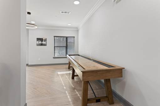 a pool table in a room with white walls and wood floors