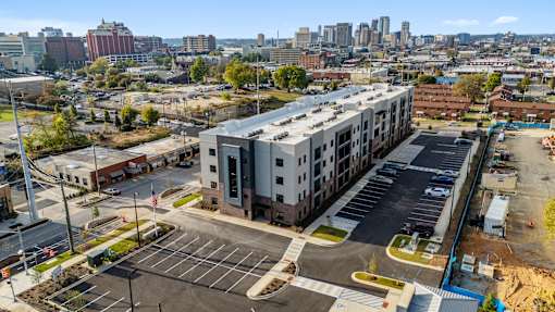 an aerial view of an apartment building in front of a city