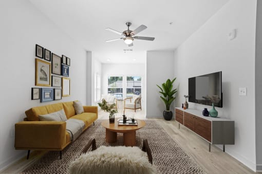a living room with a yellow couch and a tv