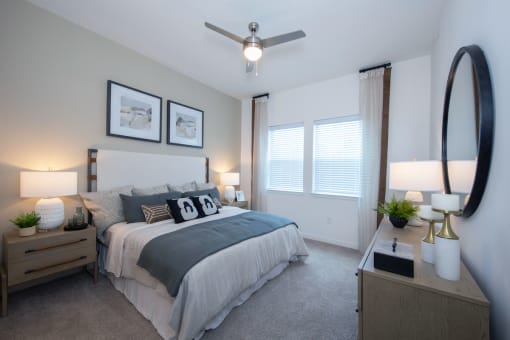 a spacious apartment bedroom with large windows, plush carpeting, and model decor at Canopy Park Apartments, Pelham, 35124