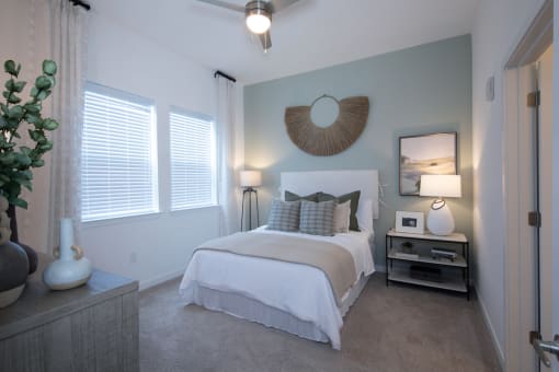 large apartment bedroom with plush carpet, ceiling fan, and model furnishings at Canopy Park Apartments, Pelham Alabama