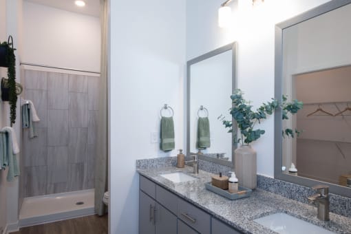 An apartment bathroom with a large shower and double vanity at Canopy Park Apartments, Alabama