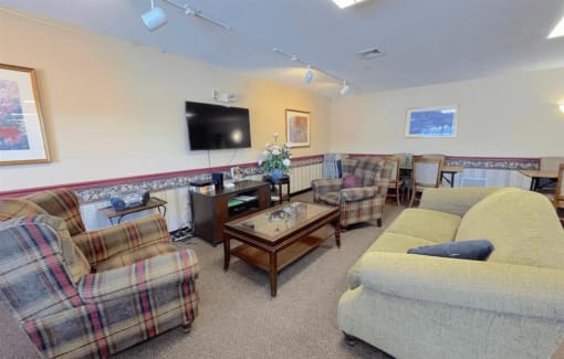 a sitting room with couches a coffee table and a tv