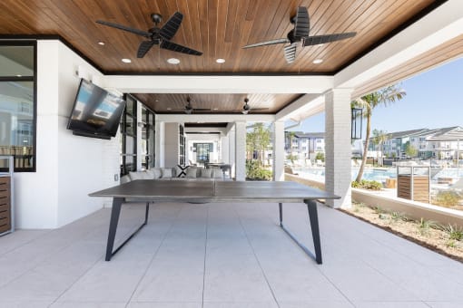 a ping pong table under ceiling fans at a relaxation deck at Lake Nona Concorde