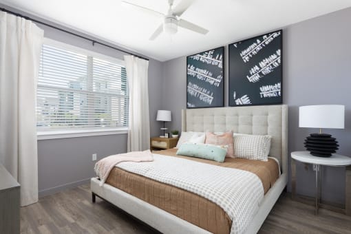 bedroom with wood-style floors, large window, and ceiling fan at Lake Nona Concorde Apartments