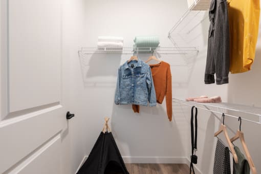 a walk in closet with built-in shelving and model clothing at Lake Nona Concorde