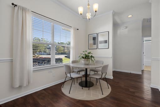 A dining room with a round table and chairs.