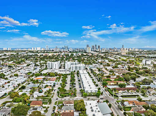 A cityscape with a mix of residential and commercial buildings under a clear sky.