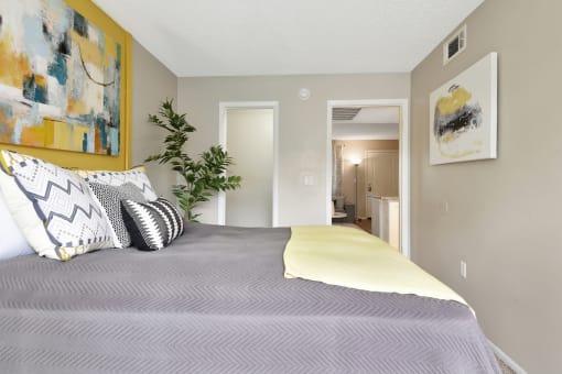 a bedroom with grey walls and yellow accents