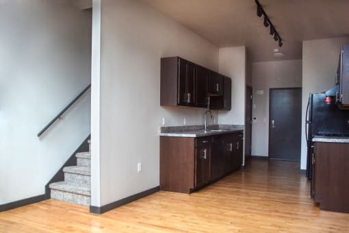 an empty kitchen with wooden floors and wooden cabinets
