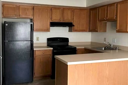 a kitchen with wooden cabinets and a black appliances