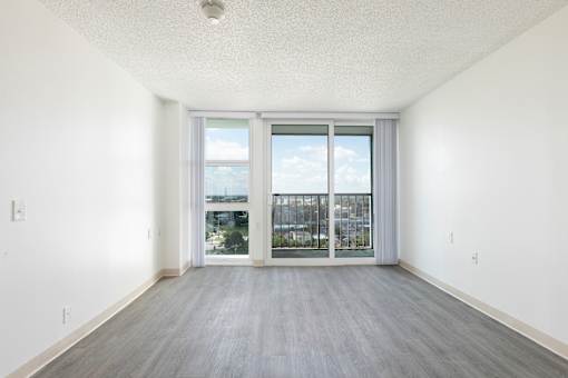 A room with a sliding glass door leading to a balcony.