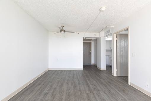 A room with a ceiling fan and a doorway leading to another room.