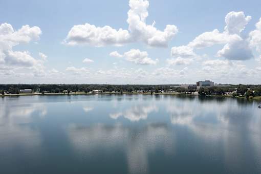 A serene lake with a clear reflection of the sky and clouds.