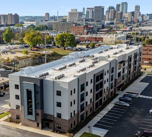 an aerial view of an apartment building with a city in the background