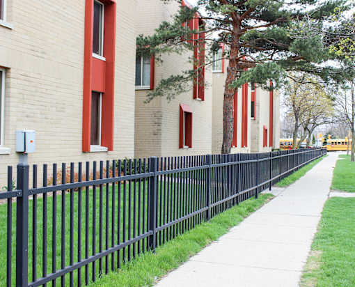 A black metal fence runs along the side of a building.