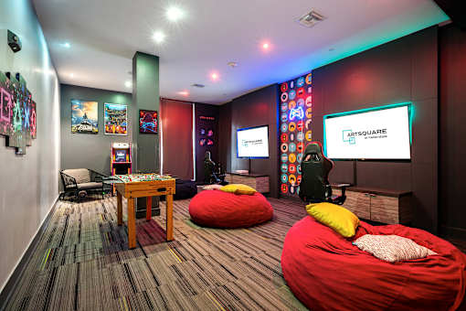 A room with a red bean bag chair and a sign that says "ArtSquare".