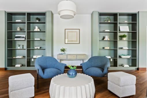 a living room with blue chairs and a white table