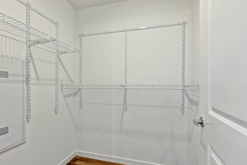 an empty closet in a home with white walls and glass doors