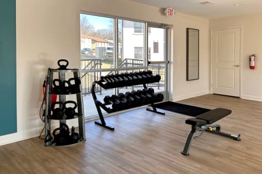 Fitness center with free weights, weight bench, and kettle bells  at Huntsville Landing Apartments, Huntsville, AL, 35806