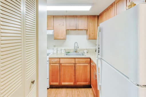 kitchen with white appliances, wood cabinets, and pantry doors