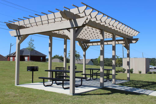 Large Pergola on a concrete slab with picnic tables and grilling stations