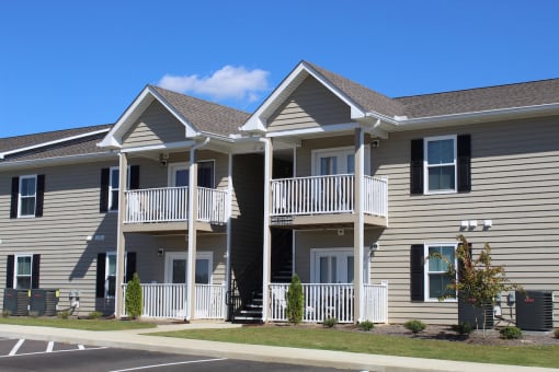Apartments with balconies, neat breezeway, trim lawns, and well-kept sidewalks